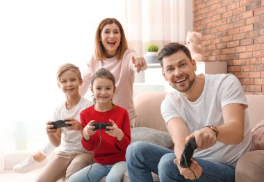 Mutlu aile oturma odasında video oyunları oynarken