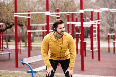 Müzik ve spor zemin üzerinde egzersiz kulaklık ile genç adam