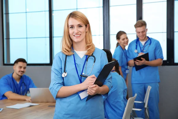 Estudiante de medicina con compañeros de grupo en la biblioteca universitaria — Foto de Stock