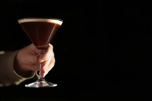 Barman segurando espresso martini cocktail na escuridão, close-up. Espaço para texto — Fotografia de Stock