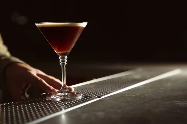 Barman serving espresso martini cocktail at counter, closeup. Space for text