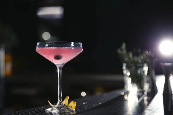 Стакан космополитического коктейля с мартини на барной стойке. Пространство для текста — стоковое фото