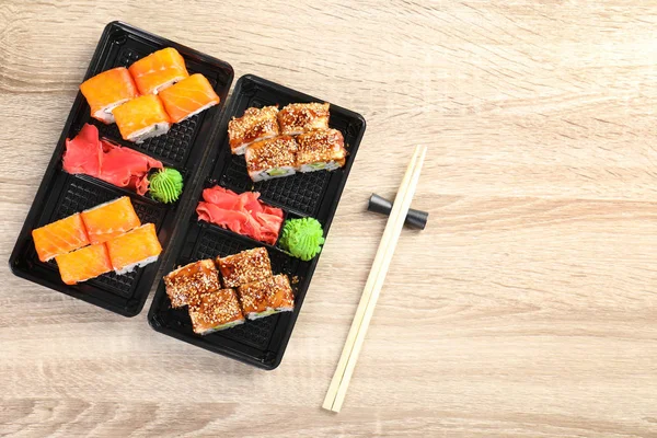 Na dřevěný stůl, pohled shora s prostorem pro text podává chutné sushi rolls. Rozvoz jídel — Stock fotografie