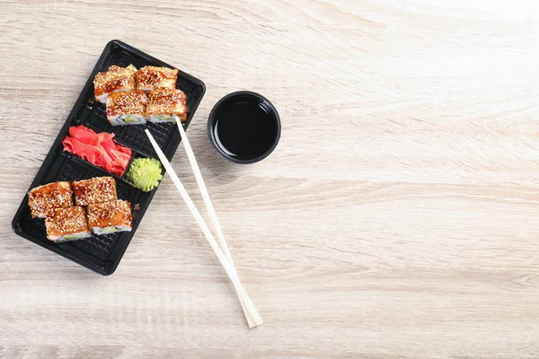 Rolos de sushi saborosos servidos em mesa de madeira, vista superior com espaço para texto. Entrega de alimentos — Fotografia de Stock