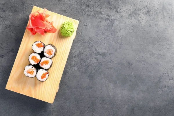 Válce chutné sushi podávané na šedý stůl, pohled shora s prostorem pro text. Rozvoz jídel — Stock fotografie