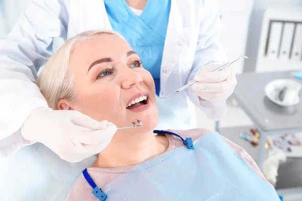 Dentiste examinant les dents du patient dans une clinique moderne — Photo