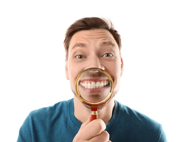 Hombre sonriente con dientes perfectos y lupa sobre fondo blanco — Foto de Stock