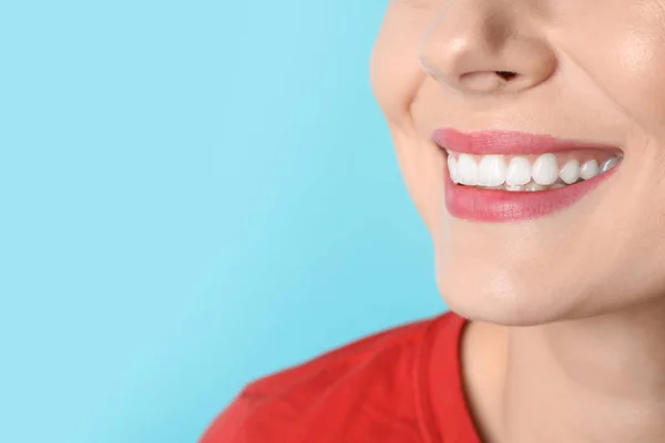 Wanita tersenyum dengan gigi yang sempurna pada latar belakang warna, closeup. Ruang untuk teks — Stok Foto
