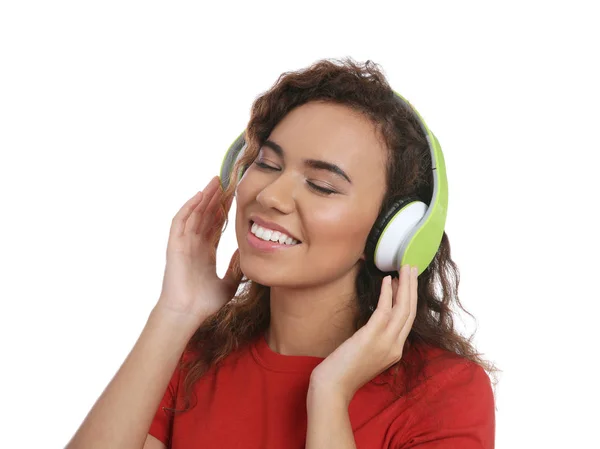 Chica afroamericana escuchando música con auriculares sobre fondo blanco —  Fotos de Stock