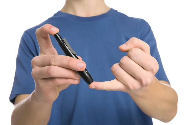 Adolescente usando caneta lancet no fundo branco, close-up. Controlo da diabetes — Fotografia de Stock