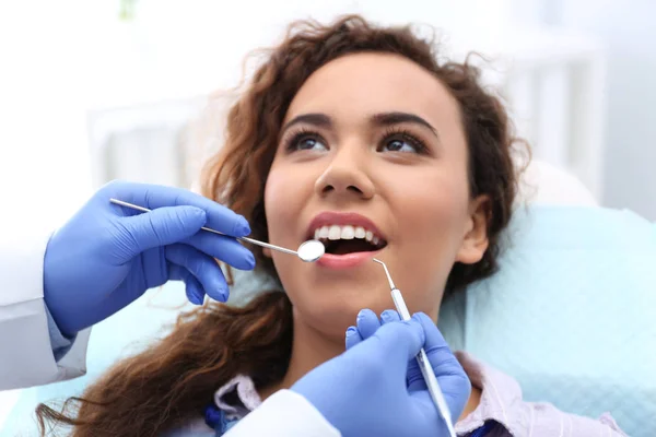 歯科プローブと病院内のミラーのアフリカ系アメリカ人の女性の歯を調べること — ストック写真