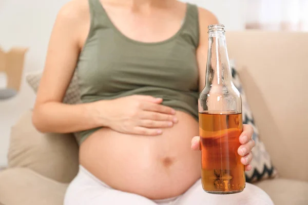 Femme enceinte avec une bouteille de whisky à la maison. Addiction à l'alcool — Photo