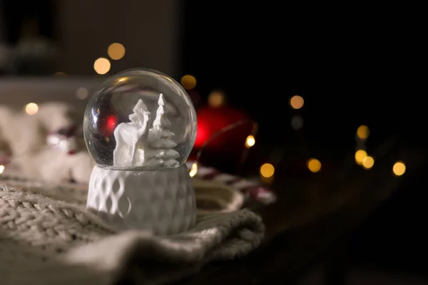 Χριστουγεννιάτικη χιονόμπαλα με πλεκτά ρούχα σε θολή φόντο. Χώρος για κείμενο — Φωτογραφία Αρχείου