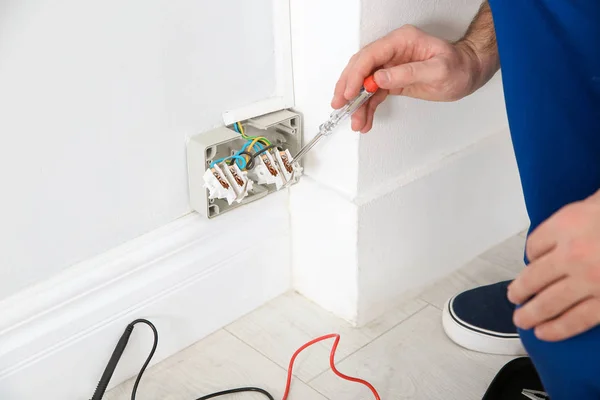 Electricista con probador de lámpara de neón comprobando voltaje en interiores, primer plano —  Fotos de Stock