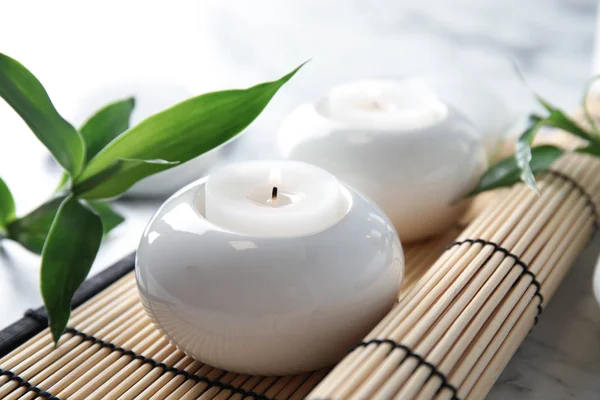Mooie wellness samenstelling met kaarsen en bamboe mat op tafel — Stockfoto