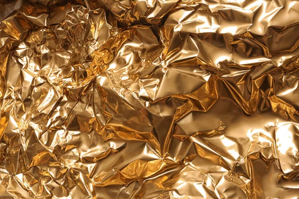 Zmięty złotej folii jako tło, widok zbliżenie — Zdjęcie stockowe