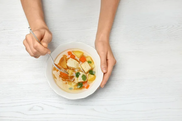 Vrouw verse zelfgemaakte kippensoep eten aan tafel, bovenaanzicht. Ruimte voor tekst — Stockfoto