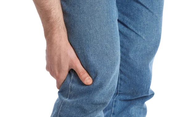 Young man suffering from leg pain on white background, closeup — Stock Photo, Image