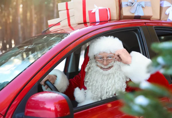 Authentic Santa Claus driving car with gift boxes, view from outside — Stock Photo, Image