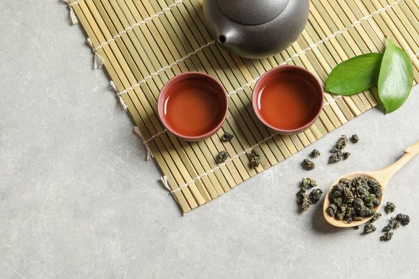 Composizione con cucchiaio di Tie Guan Yin Tè Oolong e bevanda preparata sul tavolo grigio, vista dall'alto. Spazio per testo — Foto Stock