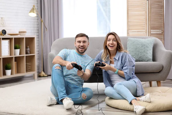 Jeune couple jouer à un jeu vidéo à la maison — Photo