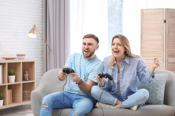 Jeune couple jouer à un jeu vidéo à la maison — Photo