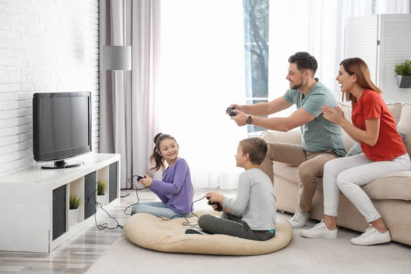 Happy family playing video games in living room