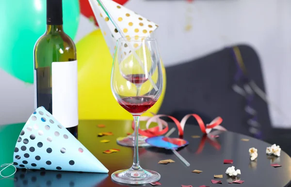 Messy table with bottle of wine and glasses against blurred background. After party chaos — Stock Photo, Image