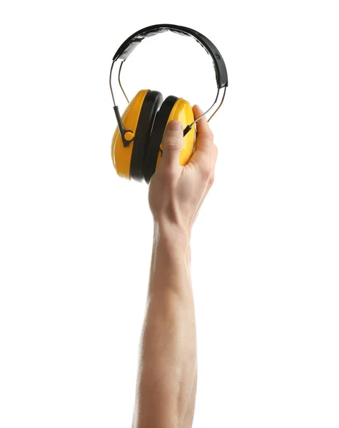 Hombre sosteniendo auriculares protectores sobre fondo blanco. Herramientas de construcción — Foto de Stock