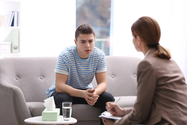 Psychotherapist working with young man in office