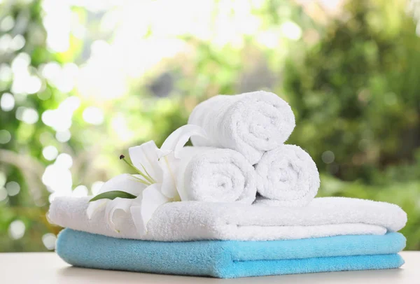 Měkké ručníky a květiny na stole rozostřeného pozadí — Stock fotografie