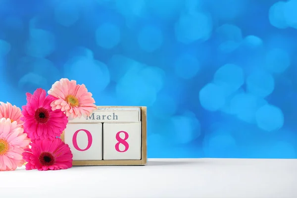 Kalender och blommor på bordet mot färg bakgrunden, utrymme för text. Internationella kvinnodagen — Stockfoto