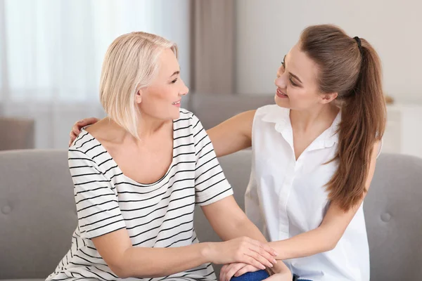 Porträt einer reifen Frau und ihrer Tochter auf dem Sofa im Wohnzimmer — Stockfoto