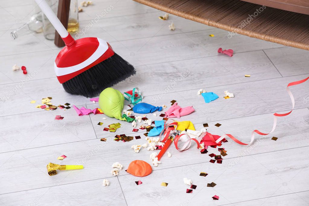 Sweeping trash after party with bristle broom indoors