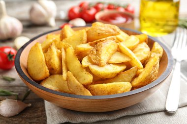 Lezzetli fırında patates dilimleri üzerinde ahşap masa ile plaka