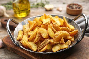 Lezzetli fırında patates dilimleri üzerinde ahşap masa ile kızartma tavası