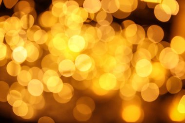 Koyu arka plan üzerinde bokeh etkisi ile altın glitter