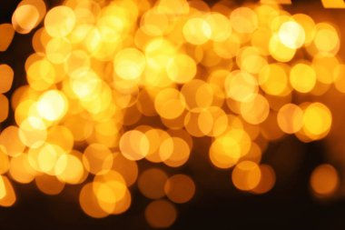 Koyu arka plan üzerinde bokeh etkisi ile altın glitter