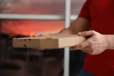 Kurye ile pizza kutusu arka plan bulanık, closeup üzerinde