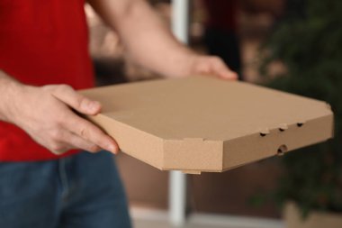 Kurye ile pizza kutusu arka plan bulanık, closeup üzerinde. Metin için yer