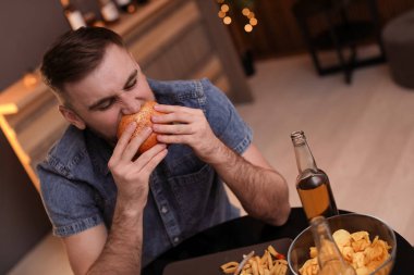 Genç adam kafede lezzetli hamburger yeme