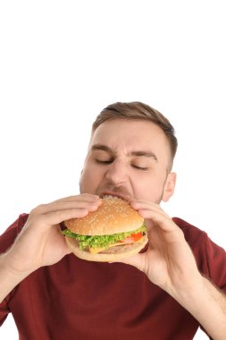 Genç adam beyaz zemin üzerine lezzetli hamburger yeme