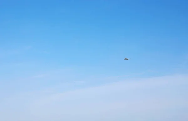 Distant view of modern airplane in blue sky — Stock Photo, Image