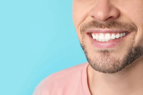 Homem sorridente com dentes perfeitos no fundo da cor, close-up. Espaço para texto — Fotografia de Stock