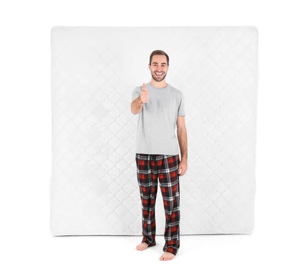 Young man with comfortable mattress isolated on white — Stock Photo, Image