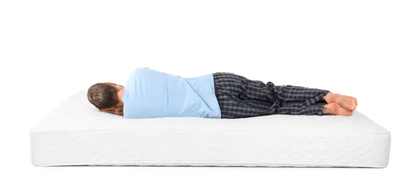 Jeune homme couché sur matelas sur fond blanc — Photo