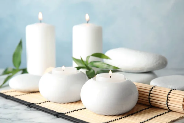 Hermosa composición de spa con velas y estera de bambú en la mesa —  Fotos de Stock