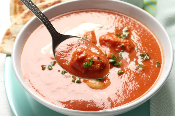 Lžíce s chutné máslo kuřecí nad misku jídla, closeup. Tradiční pokrm Murgh Makhani — Stock fotografie