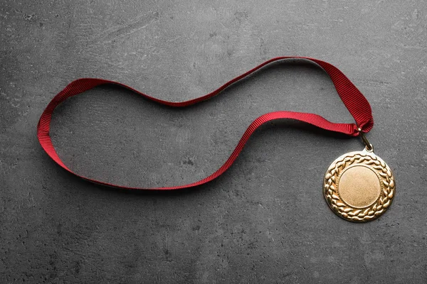 Medalha de ouro com espaço para design em fundo cinza, vista superior. Conceito de vitória — Fotografia de Stock