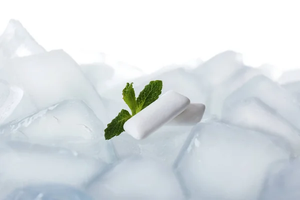 Tuggummin och mynta på isbitar mot vit bakgrund, närbild — Stockfoto
